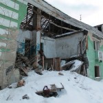 Обрушившиеся потолки, выставленные окна, мусор внутри. А когда-то это была центральная улица поселка. Фото: Константин Бобылев, «Глобус»