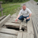 Сергей Куклин показывает на яму в покрытии моста. Фото: Константин Бобылев, "Глобус".