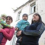 Альбина (слева) и Екатерина со своими детьми. на заднем плане пристрой десткого сада, кровля которого отремонтирована пленкой. Фото: Константин Бобылев, "Глобус".